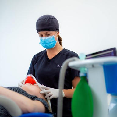 Assistante dentaire préparant le patient avant une opération de chirurgie orale